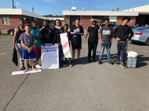 junior high boys holding signs advertising their free car wash