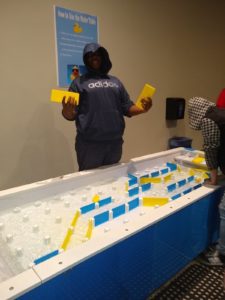 student works with interactive exhibit at science museum