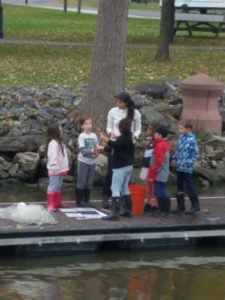 children and teacher standing dock