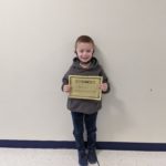 elementary student holding Kindness Certificate