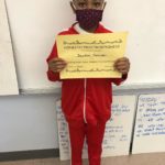elementary student holding Honesty/Trustworthiness Certificate