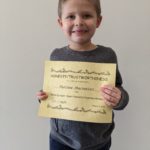 elementary student holding Honesty/Trustworthiness Certificate