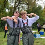 two high school boys outdoors wearing chest waders