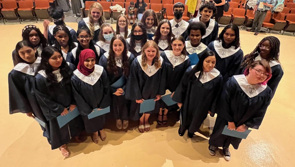 23 high school students in blue robes and white stoles for National Honor Society